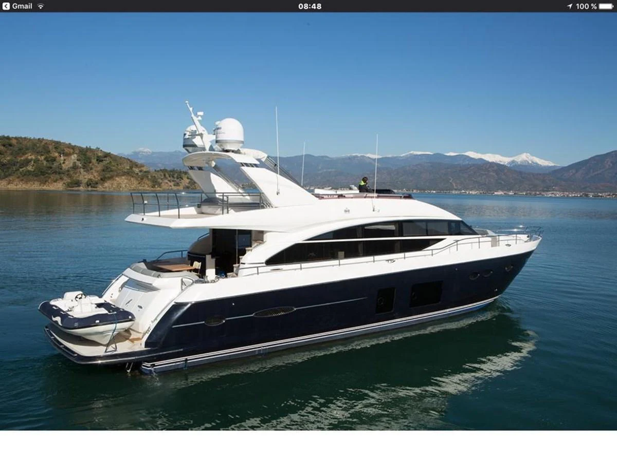 A sleek and modern yacht cruising on calm waters with scenic mountains in the background. aboard RAINBOW Yacht for Sale
