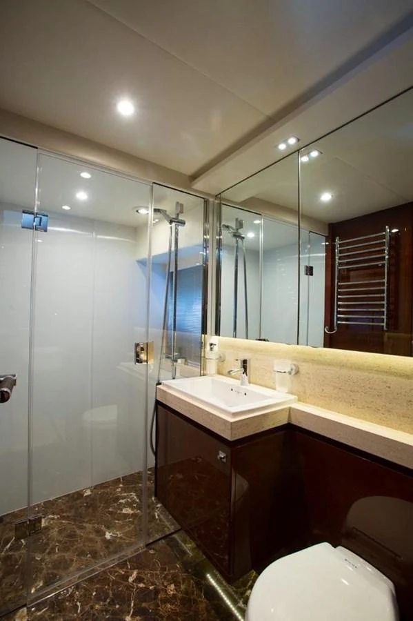 The yacht's bathroom features a sleek design with a glass-enclosed shower and modern fixtures. aboard RAINBOW Yacht for Sale