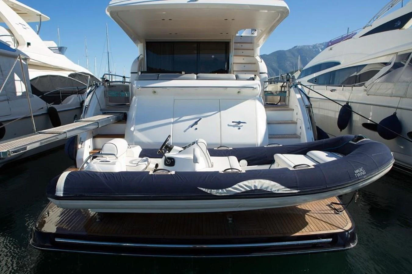 A sleek tender is docked at the stern of a luxurious yacht, ready for excursions. aboard RAINBOW Yacht for Sale