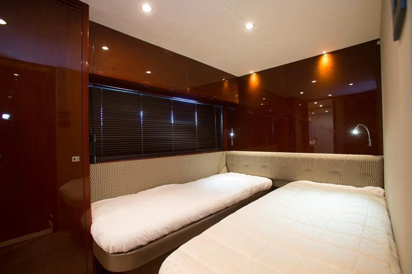 The twin stateroom features two comfortable single beds with modern lighting and elegant wood finishes. aboard RAINBOW Yacht for Sale