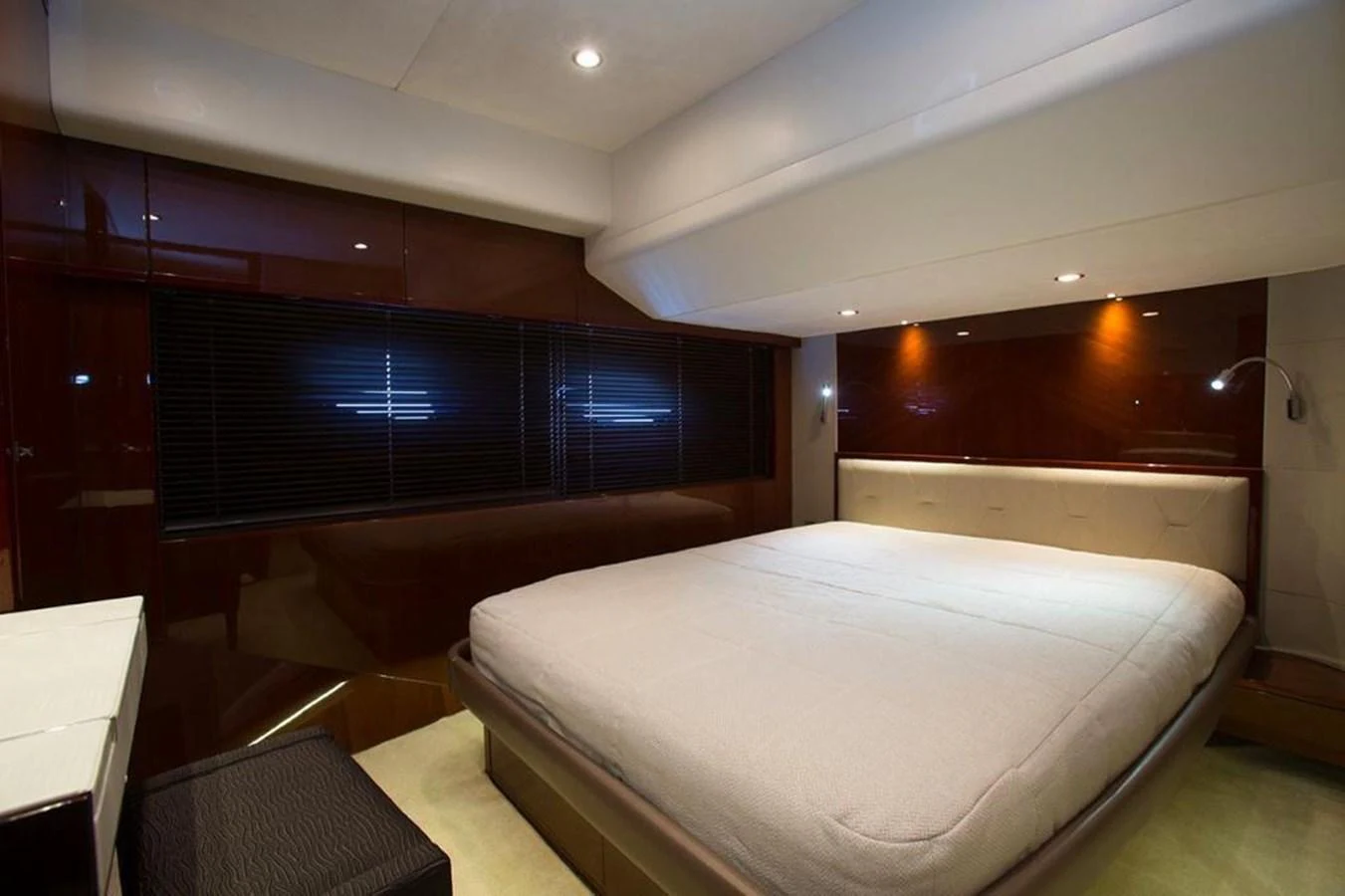 The stateroom features a spacious bed with modern lighting and sleek wood finishes. aboard RAINBOW Yacht for Sale