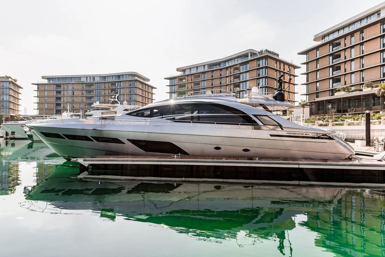 A sleek and modern yacht docked in a marina, reflecting beautifully on the calm water. aboard 2021 PERSHING 8X Yacht for Sale