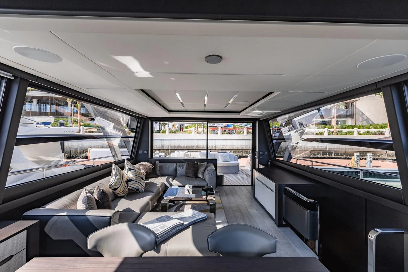 The salon features modern furnishings with ample natural light and a spacious seating area. aboard 2021 PERSHING 8X Yacht for Sale