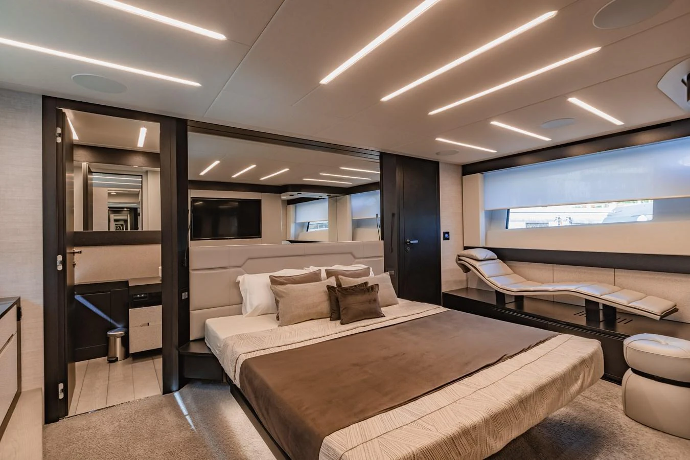 The master stateroom features a luxurious bed, modern lighting, and ample natural light from large windows. aboard 2021 PERSHING 8X Yacht for Sale