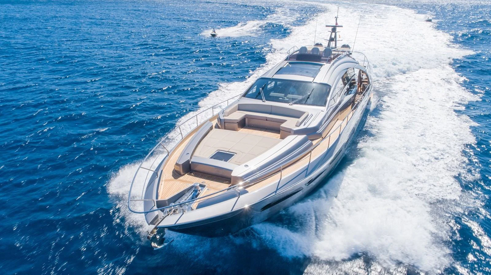 A sleek and modern yacht cruises swiftly through the open sea, leaving a trail of white wake behind. aboard DESERT STAR Yacht for Sale