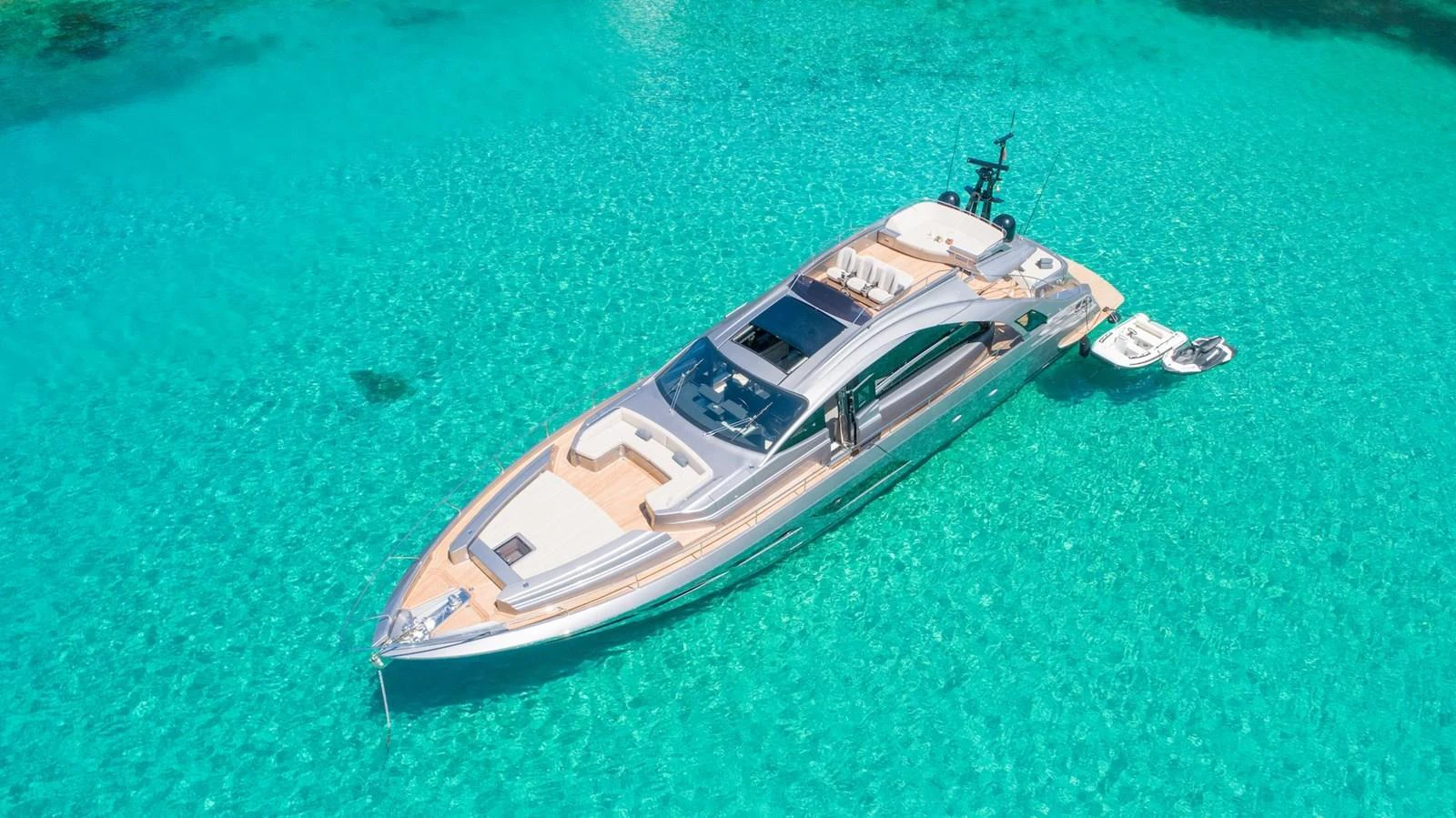 A sleek yacht glides gracefully on crystal-clear turquoise waters. aboard DESERT STAR Yacht for Sale