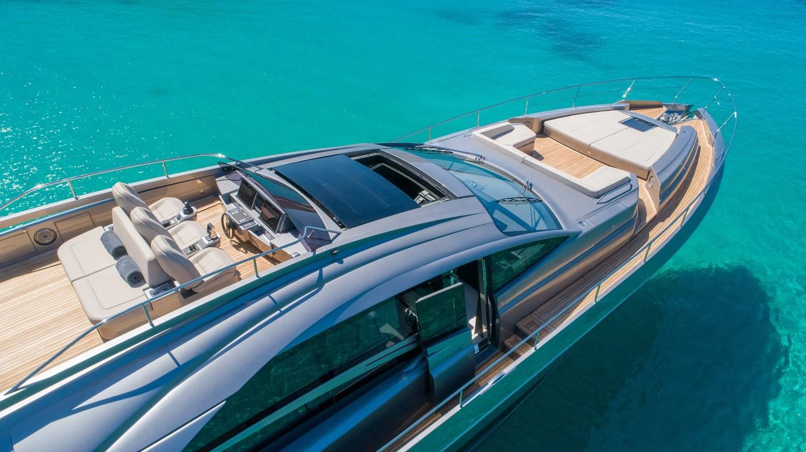 A sleek and modern yacht with a spacious flybridge, cruising in crystal-clear turquoise waters. aboard DESERT STAR Yacht for Sale