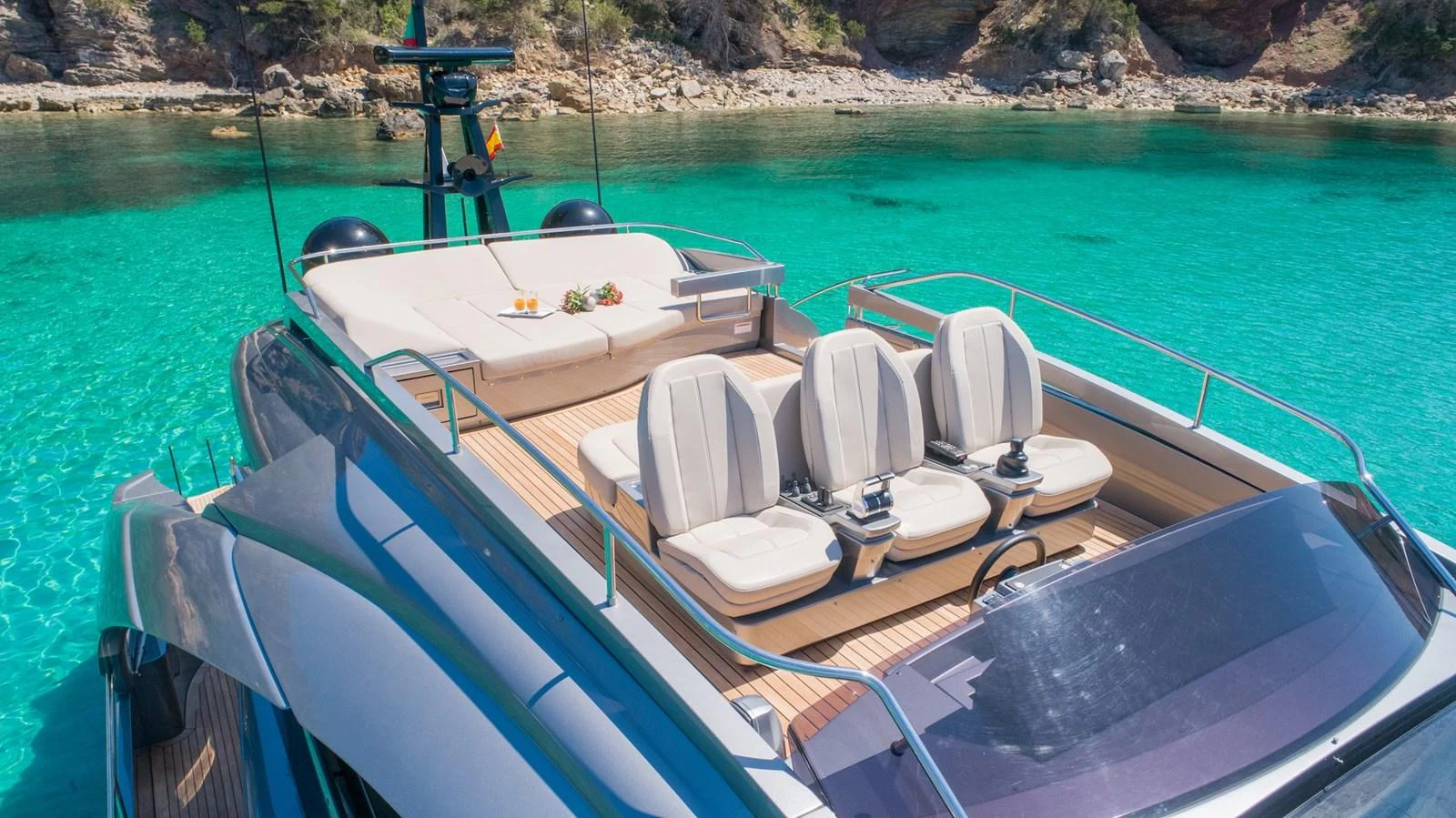 The yacht's aft deck offers a luxurious seating area with stunning views of the clear turquoise waters. aboard DESERT STAR Yacht for Sale