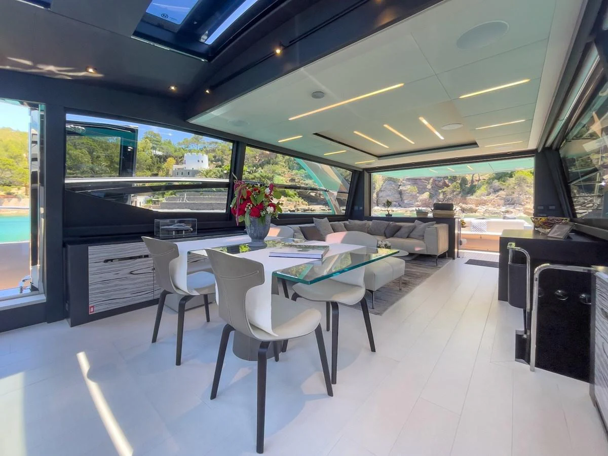 The yacht's salon features a modern dining area with large windows offering scenic views. aboard DESERT STAR Yacht for Sale
