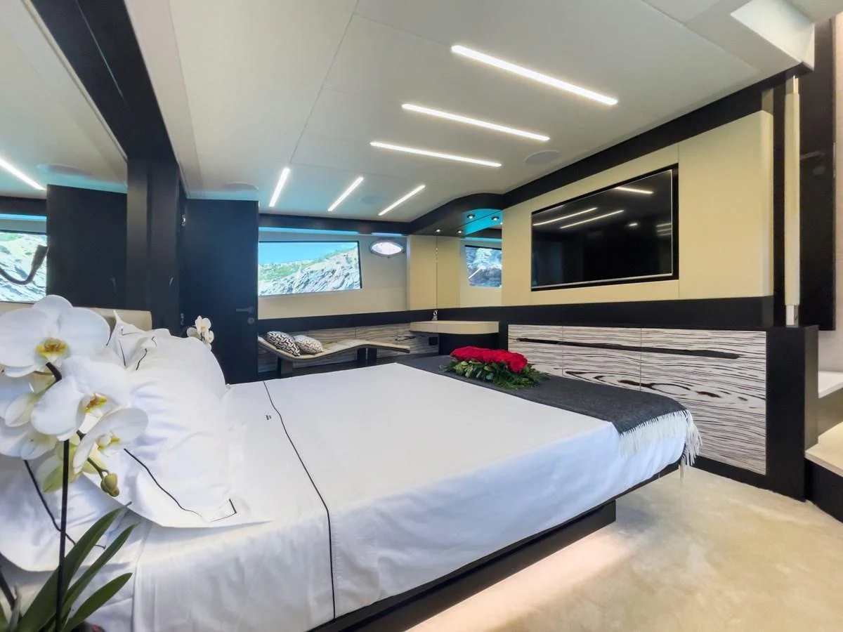 The master stateroom features a luxurious bed, modern decor, and ample natural light. aboard DESERT STAR Yacht for Sale