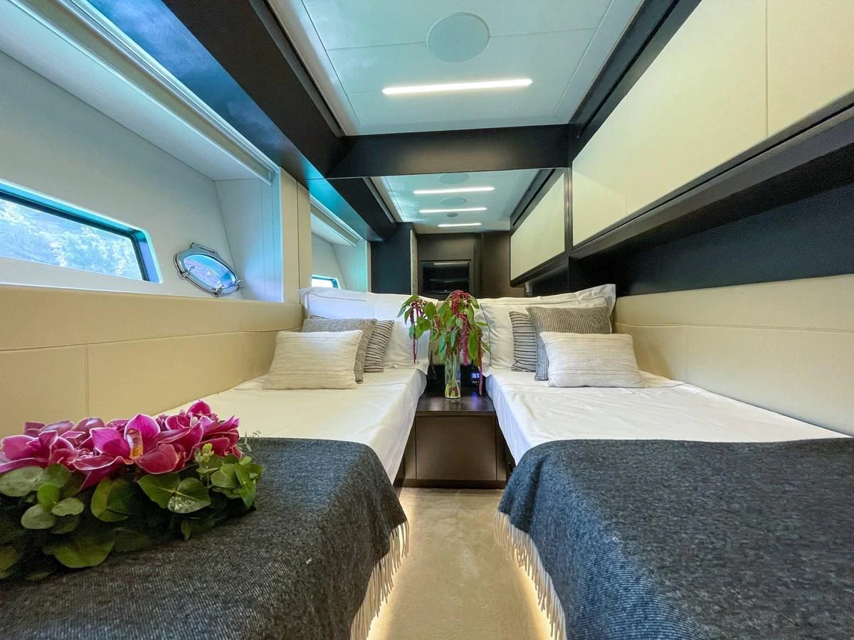 The guest stateroom features twin beds with elegant bedding and a modern, cozy atmosphere. aboard DESERT STAR Yacht for Sale