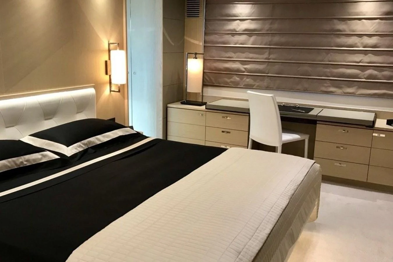 The stateroom features a luxurious bed, a desk area, and elegant lighting. aboard MS FELICE Yacht for Sale