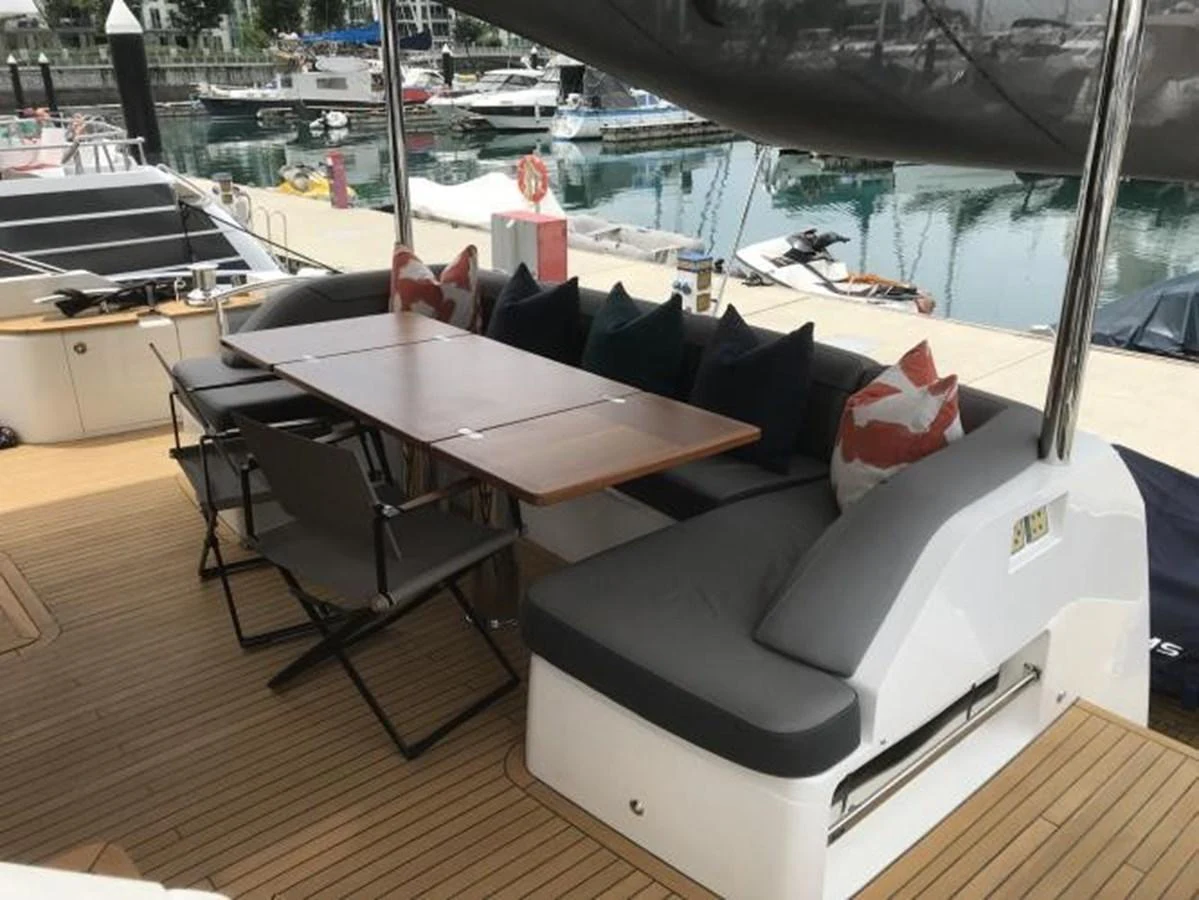 The aft deck features a comfortable seating area with a dining table, perfect for outdoor meals and relaxation. aboard ANDAMAN PRINCESS Yacht for Sale