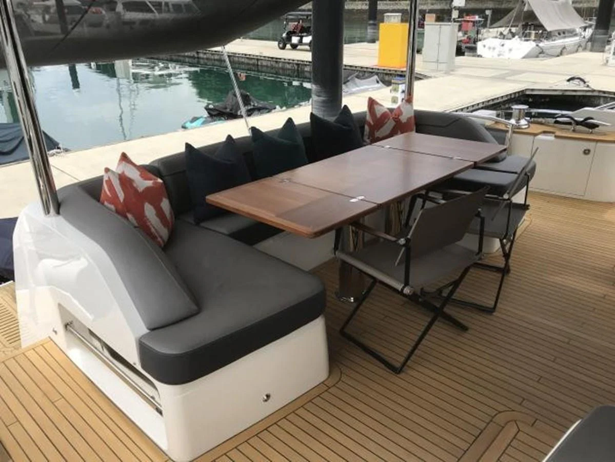 The aft deck features a comfortable seating area with a wooden dining table, perfect for alfresco dining. aboard ANDAMAN PRINCESS Yacht for Sale