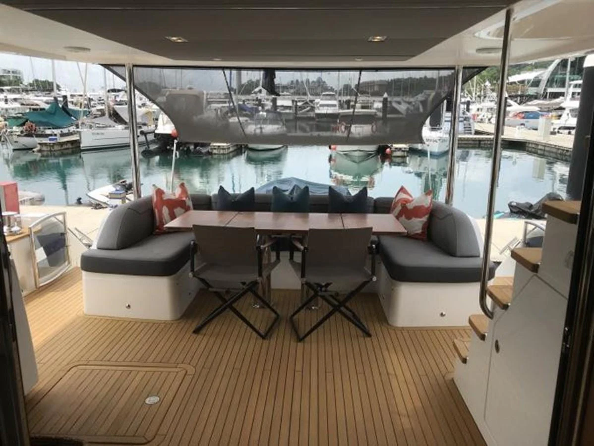 The aft deck features a comfortable seating area with a dining table, perfect for enjoying meals with a view of the marina. aboard ANDAMAN PRINCESS Yacht for Sale