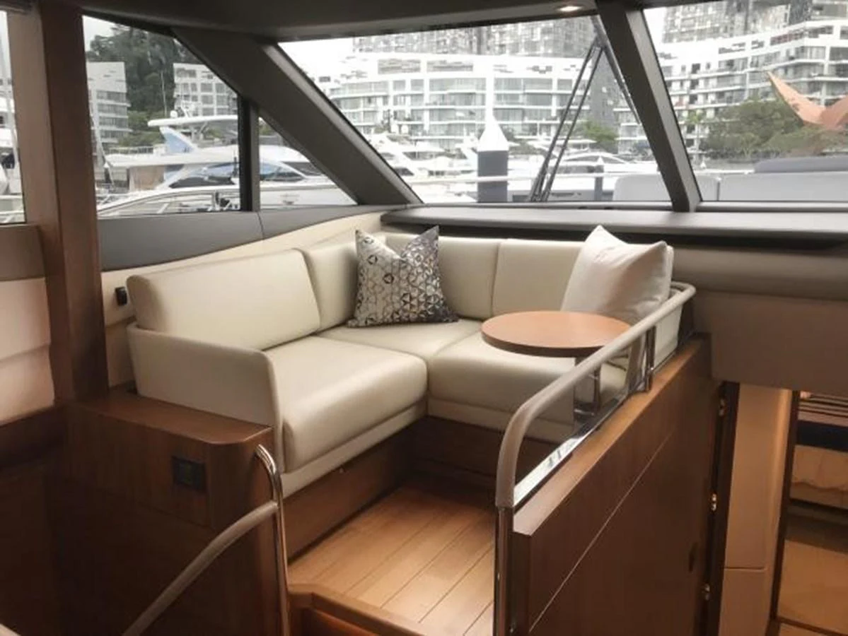 The salon features a cozy seating area with a round table, offering a comfortable space to relax while enjoying the view through large windows. aboard ANDAMAN PRINCESS Yacht for Sale