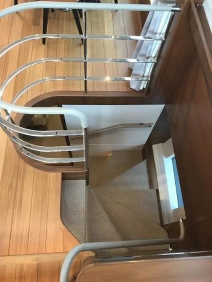 A stylish staircase with wooden steps and metal railings connects different levels of the yacht's interior. aboard ANDAMAN PRINCESS Yacht for Sale