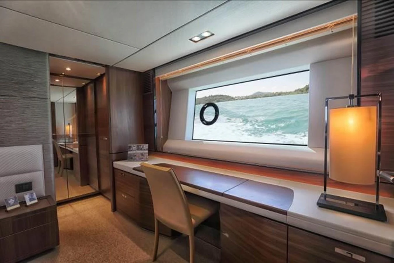 The yacht's interior features a stylish workspace with a large window offering a scenic view of the water. aboard ANDAMAN PRINCESS Yacht for Sale