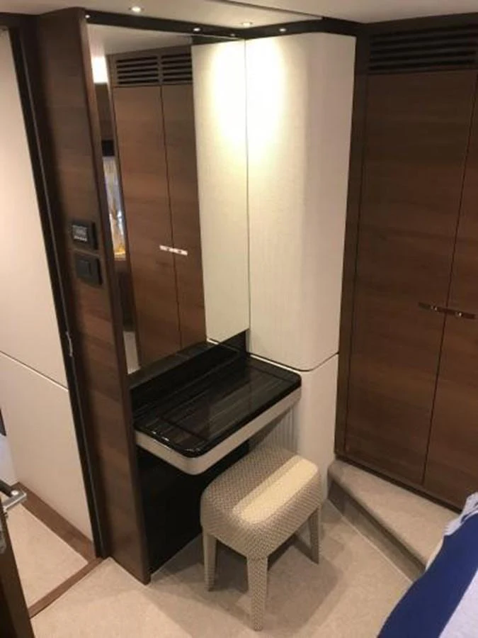 A cozy vanity area with a stool and mirror, surrounded by wooden cabinetry. aboard ANDAMAN PRINCESS Yacht for Sale