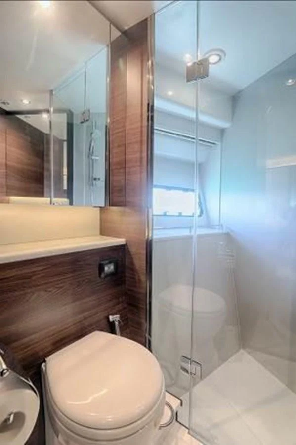 The yacht's bathroom features modern fixtures and a sleek design with wood accents and a glass-enclosed shower. aboard ANDAMAN PRINCESS Yacht for Sale