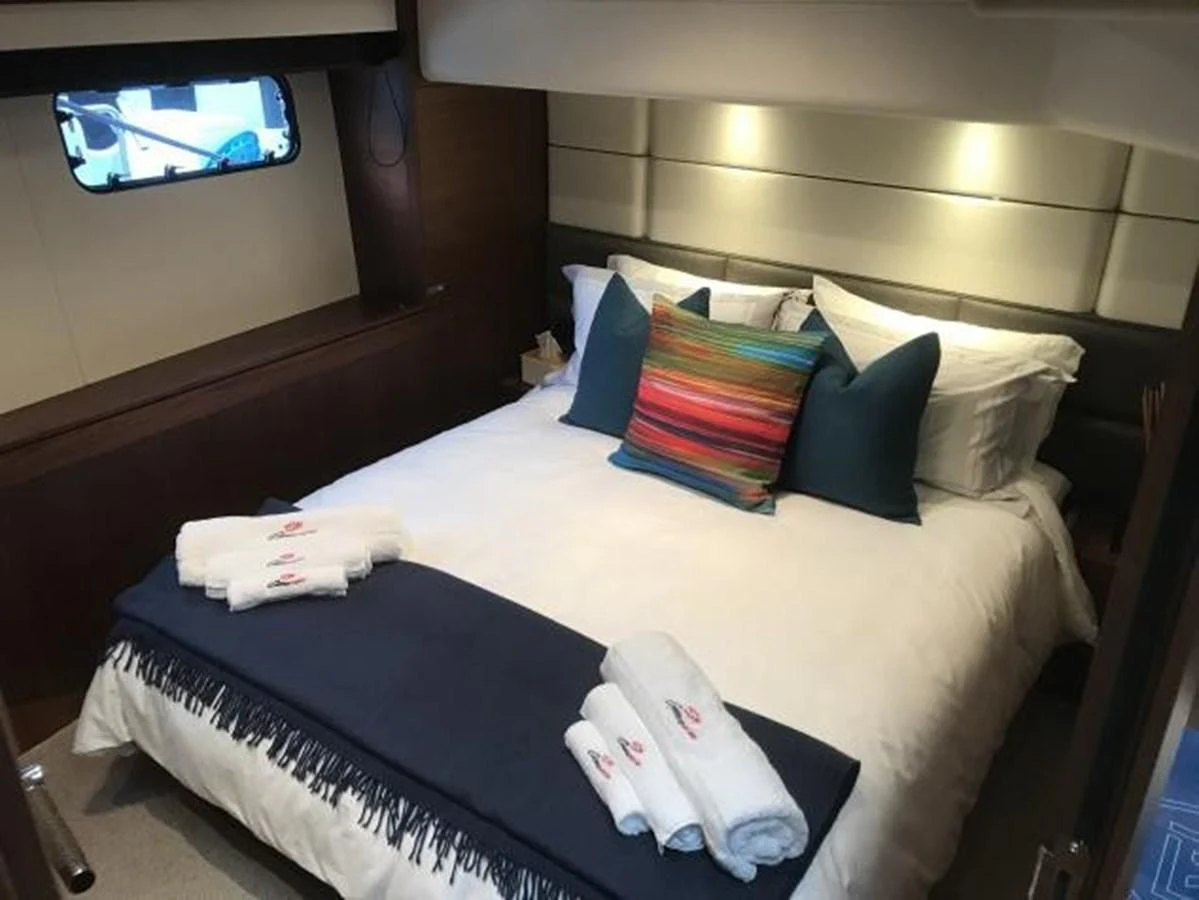 A cozy stateroom featuring a neatly made bed with colorful pillows and soft lighting. aboard ANDAMAN PRINCESS Yacht for Sale