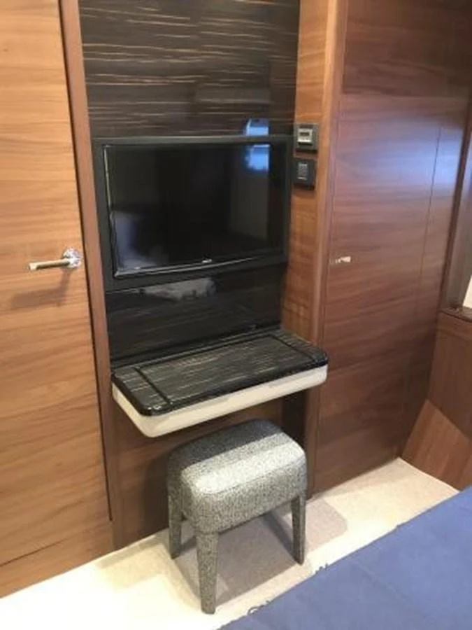 A cozy interior space featuring a wall-mounted TV and a small stool. aboard ANDAMAN PRINCESS Yacht for Sale