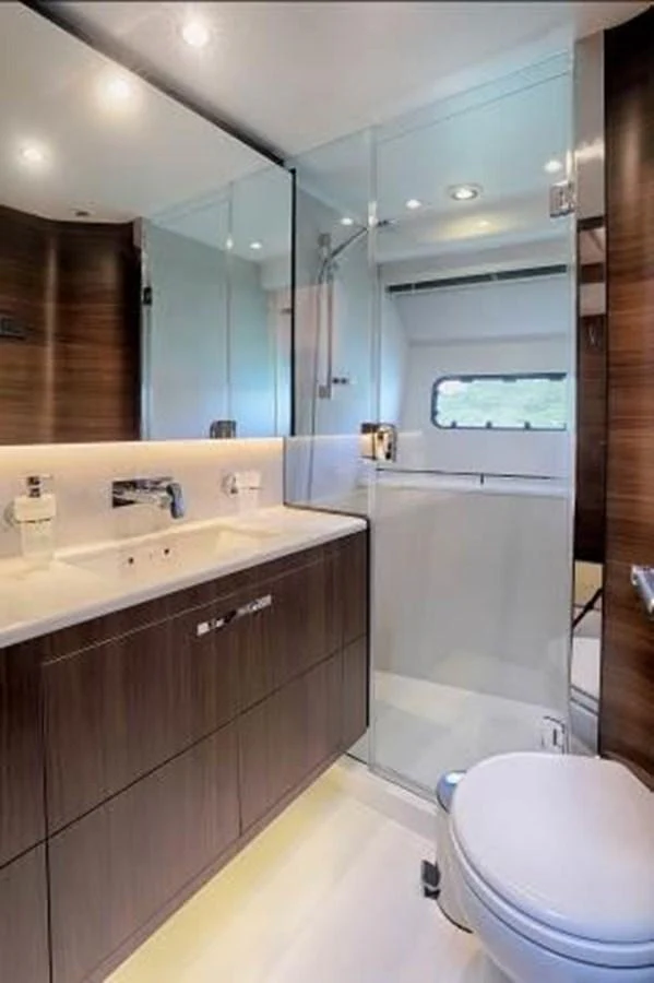 A sleek and modern yacht bathroom with a glass-enclosed shower and elegant wood finishes. aboard ANDAMAN PRINCESS Yacht for Sale
