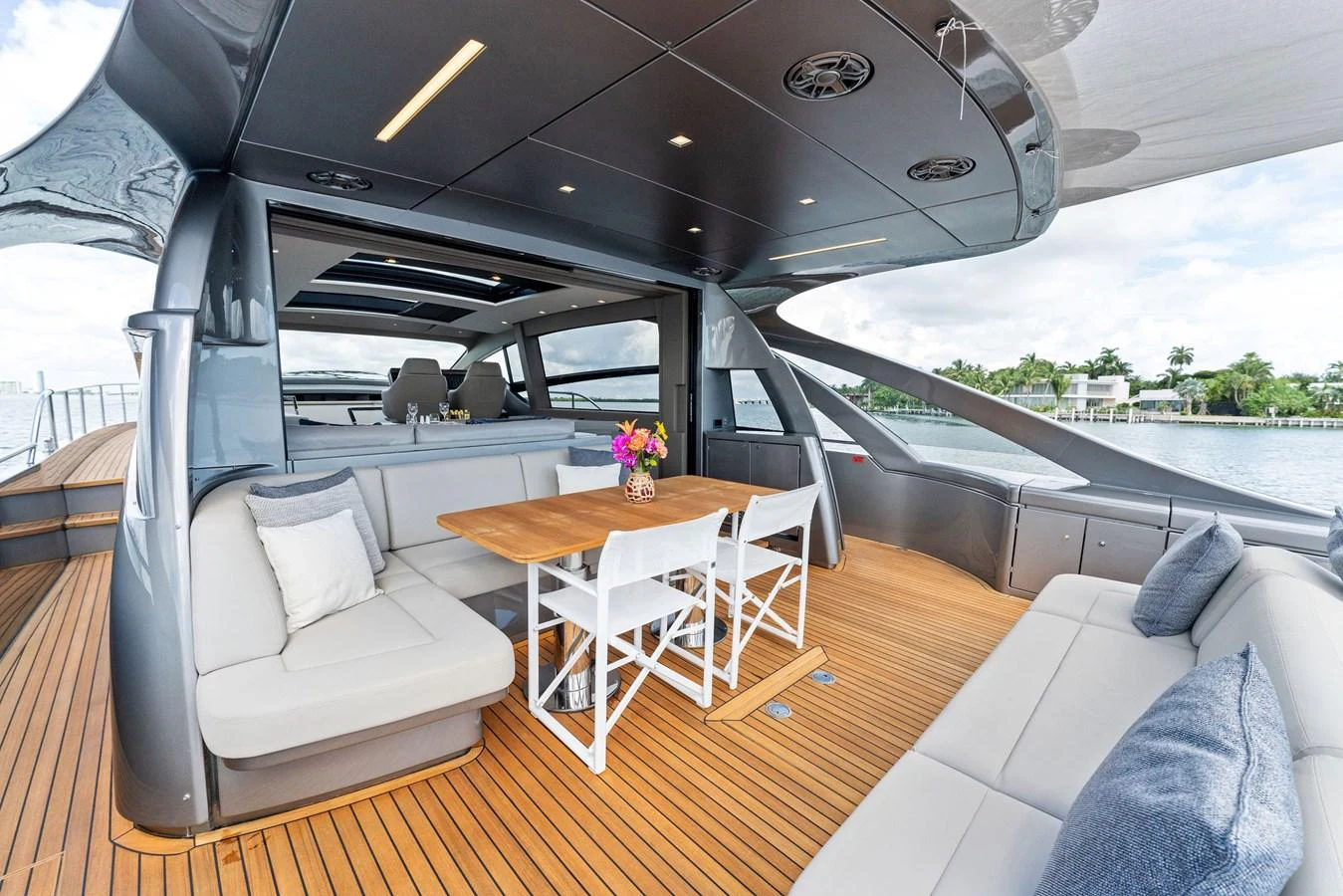 The aft deck features a stylish seating area with a wooden table and comfortable cushions, perfect for outdoor relaxation. aboard QUANTUM Yacht for Sale