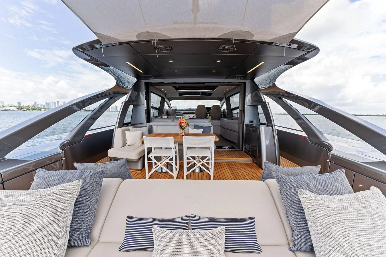 The aft deck features a comfortable seating area with a dining table, perfect for alfresco meals and relaxation. aboard QUANTUM Yacht for Sale