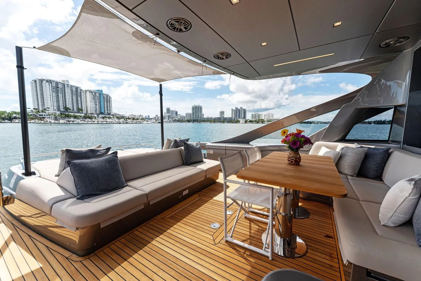 The aft deck features a comfortable seating area with a dining table, perfect for enjoying meals with a view. aboard QUANTUM Yacht for Sale