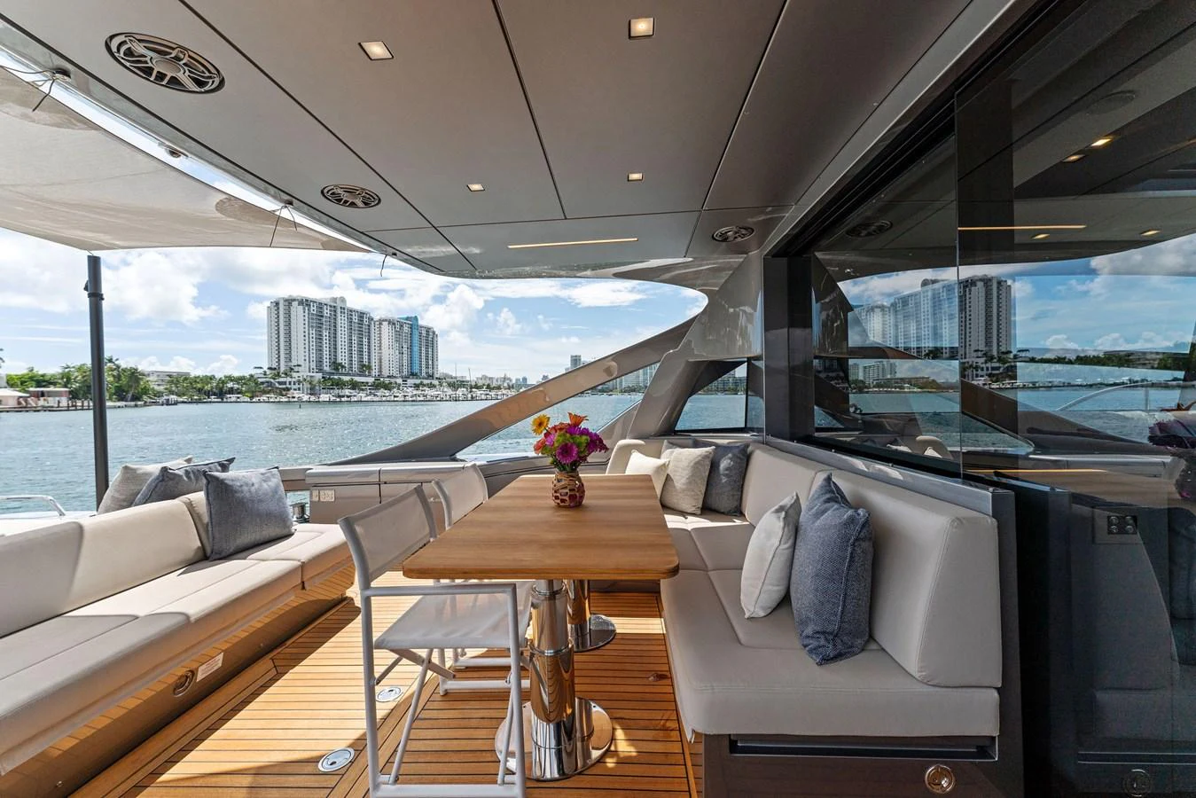 The aft deck features a comfortable seating area with a central dining table, perfect for enjoying meals with a view. aboard QUANTUM Yacht for Sale