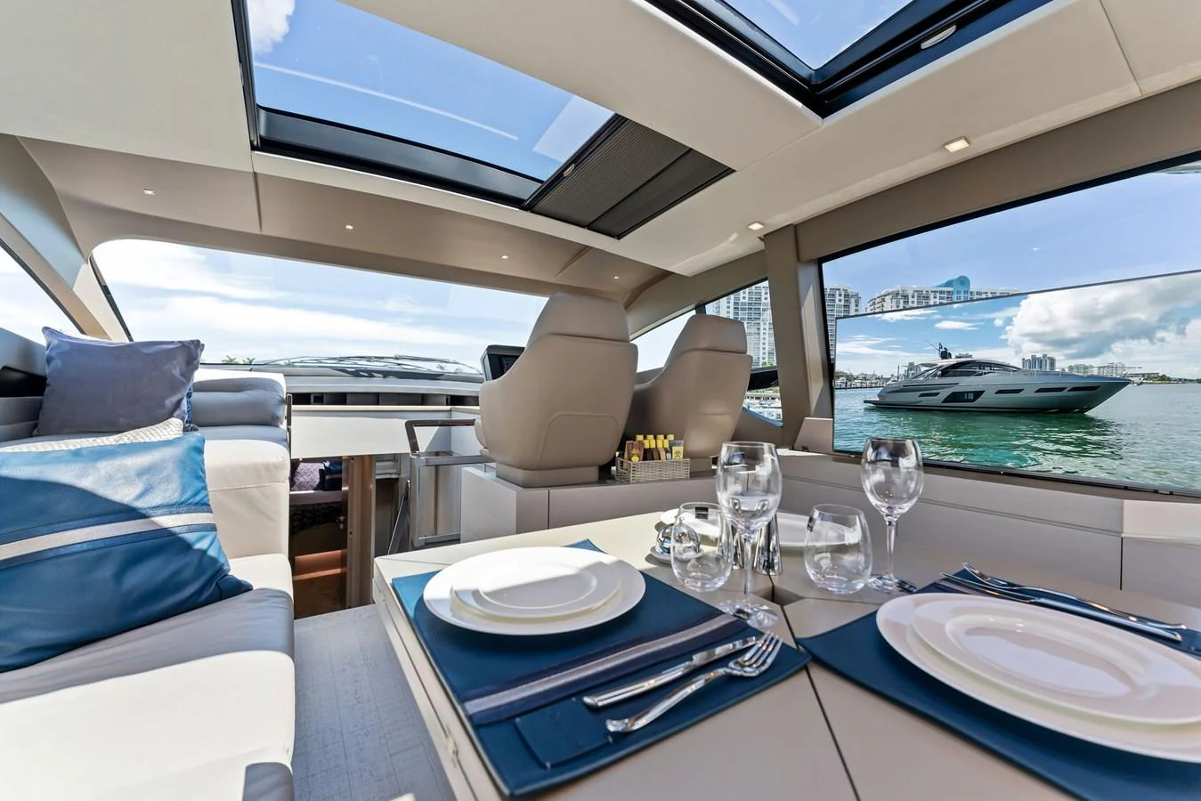 The yacht's salon features a dining area with a view of the water through large windows and skylights. aboard QUANTUM Yacht for Sale