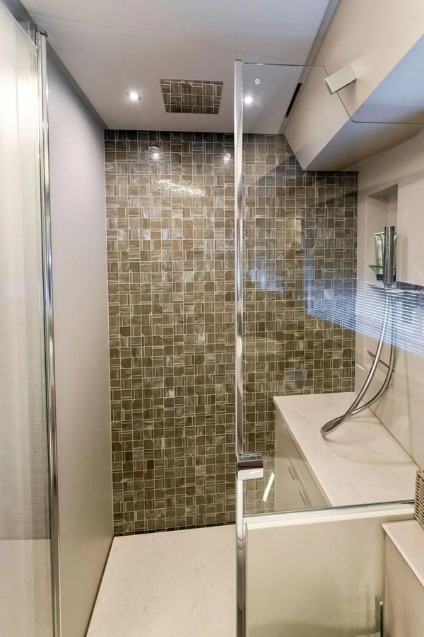 A modern yacht bathroom featuring a glass shower enclosure and stylish tile work. aboard QUANTUM Yacht for Sale