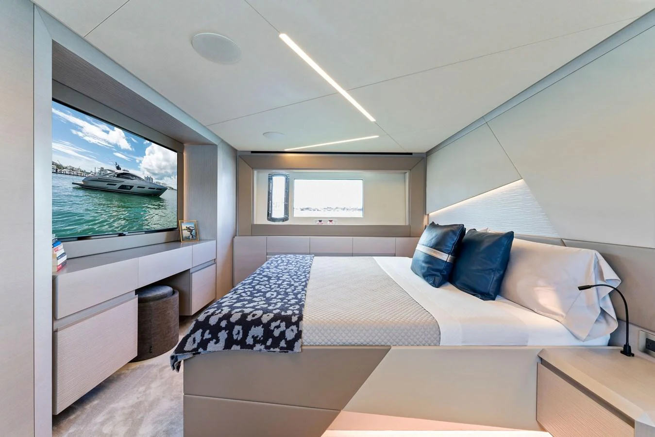A luxurious stateroom featuring a comfortable bed and a large window with a scenic view. aboard QUANTUM Yacht for Sale