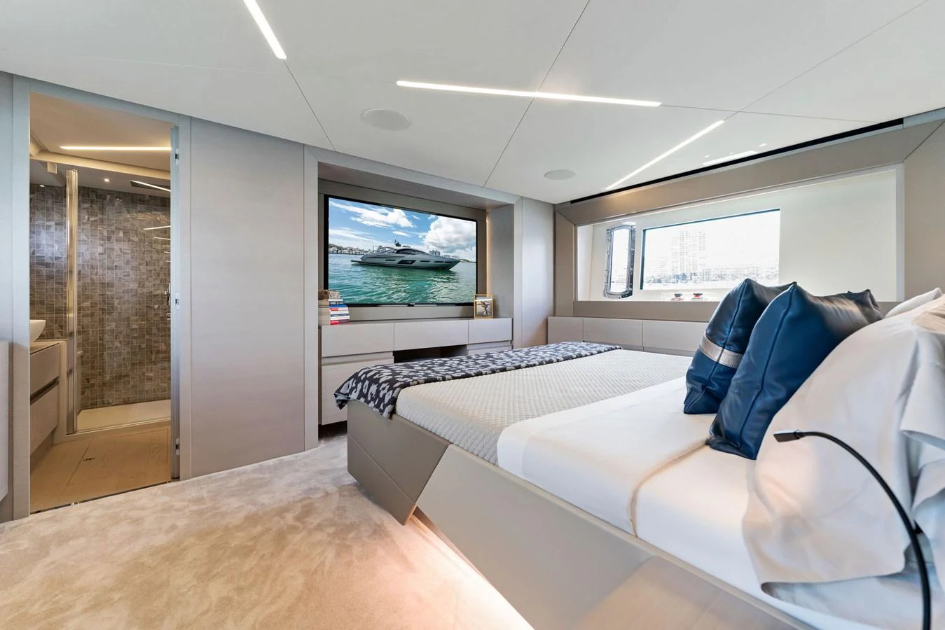 A luxurious stateroom featuring a comfortable bed, modern decor, and a large window with a view. aboard QUANTUM Yacht for Sale