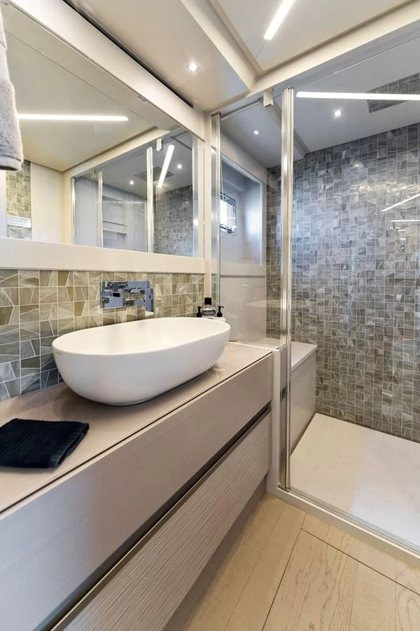 A modern yacht bathroom featuring a sleek vanity and spacious shower. aboard QUANTUM Yacht for Sale