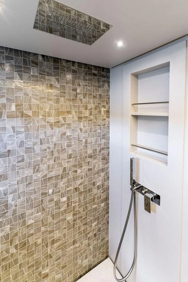A modern yacht bathroom featuring a stylish tiled shower area and sleek fixtures. aboard QUANTUM Yacht for Sale