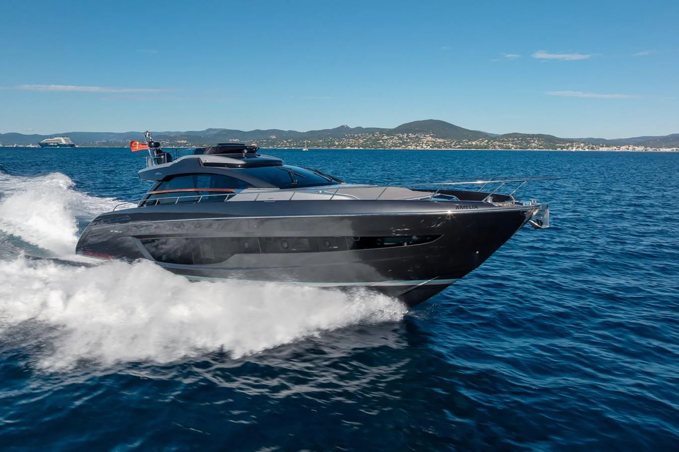 A sleek, modern yacht cruises swiftly through the open water on a clear day. aboard AMELIA Yacht for Sale