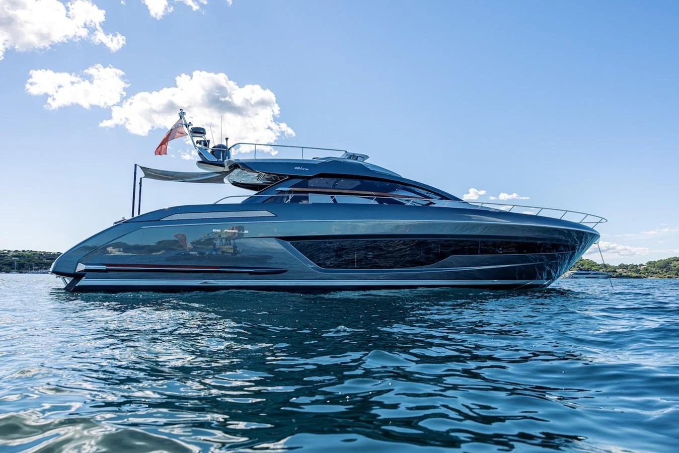 A sleek and modern yacht glides gracefully on the water under a clear blue sky. aboard AMELIA Yacht for Sale