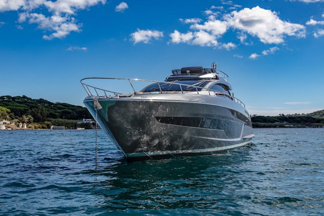 A sleek and modern yacht glides gracefully on the water under a clear blue sky. aboard AMELIA Yacht for Sale