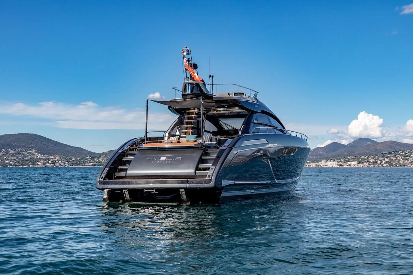 A sleek and modern yacht is anchored on calm waters with a scenic coastal backdrop. aboard AMELIA Yacht for Sale