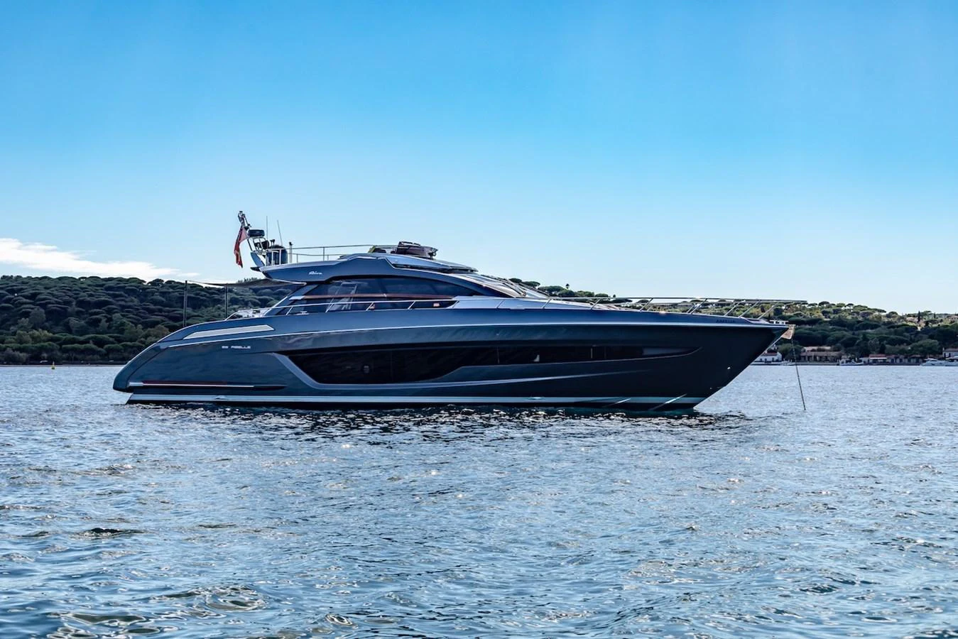 A sleek and modern yacht glides gracefully on calm waters against a scenic backdrop. aboard AMELIA Yacht for Sale