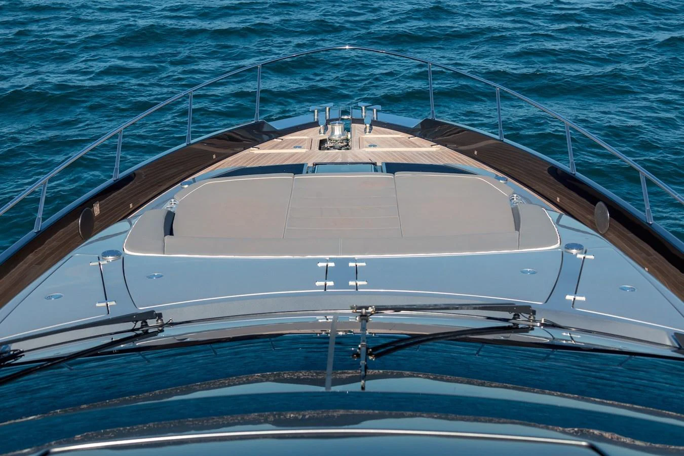 The foredeck of the yacht features a spacious sunbathing area with luxurious cushions, surrounded by sleek railings and set against the backdrop of the open sea. aboard AMELIA Yacht for Sale