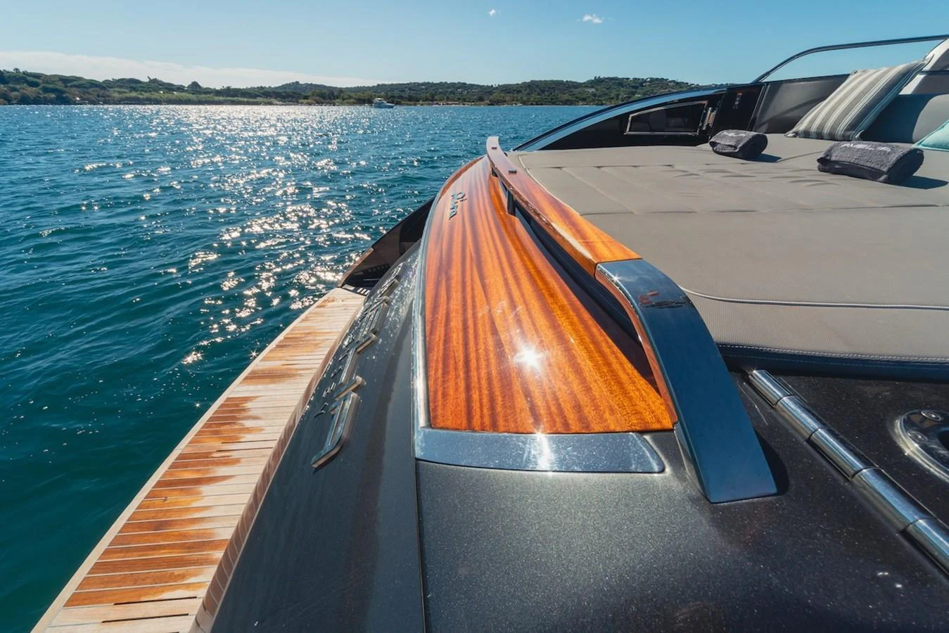 A close-up view of the yacht's sleek and polished deck with a beautiful wooden finish, set against a sparkling water backdrop. aboard AMELIA Yacht for Sale
