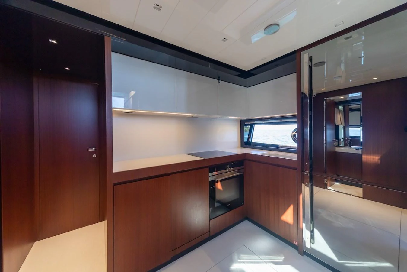 The yacht's galley features modern appliances and sleek cabinetry, bathed in natural light. aboard AMELIA Yacht for Sale