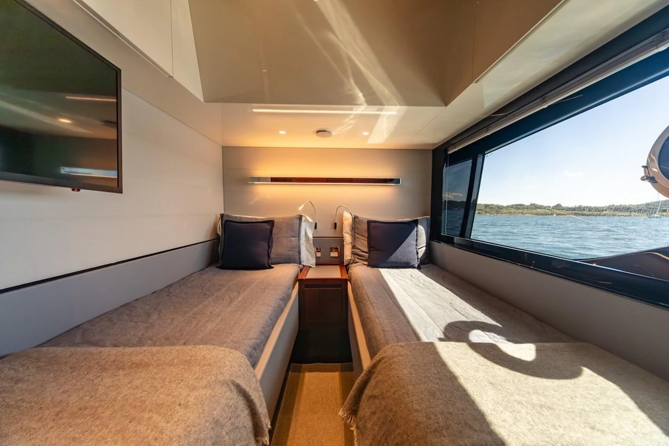 The guest stateroom features twin beds with a large window offering a scenic view of the water. aboard AMELIA Yacht for Sale