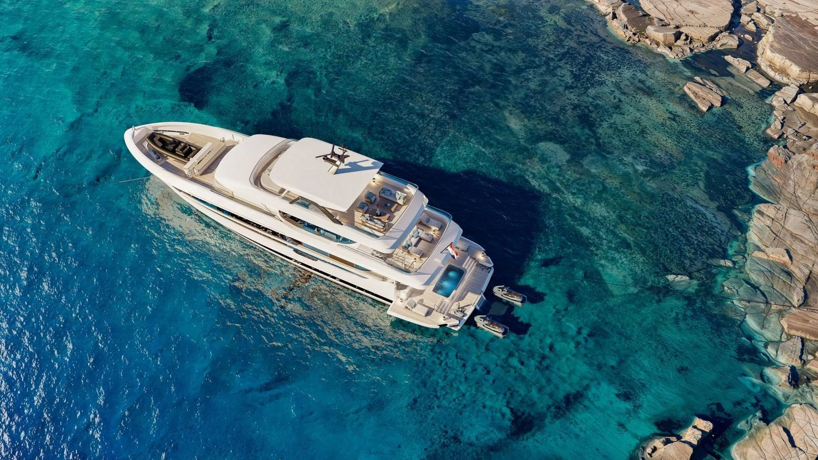 A luxurious yacht is anchored in crystal-clear turquoise waters near a rocky shoreline. aboard 133 MALLORCA Yacht for Sale