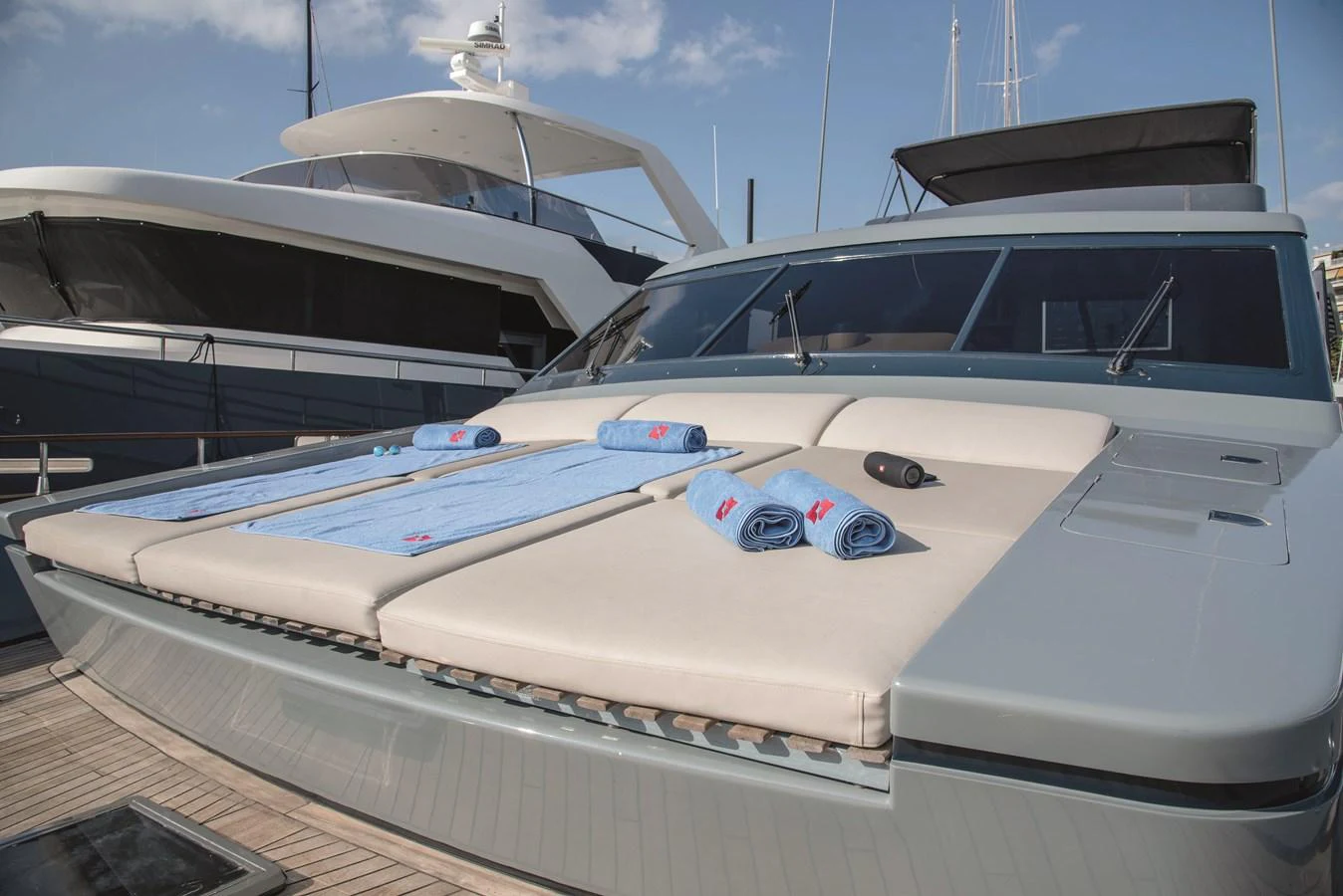 The foredeck of the yacht features comfortable sun pads with neatly placed towels, perfect for relaxation. aboard KISS Yacht for Sale
