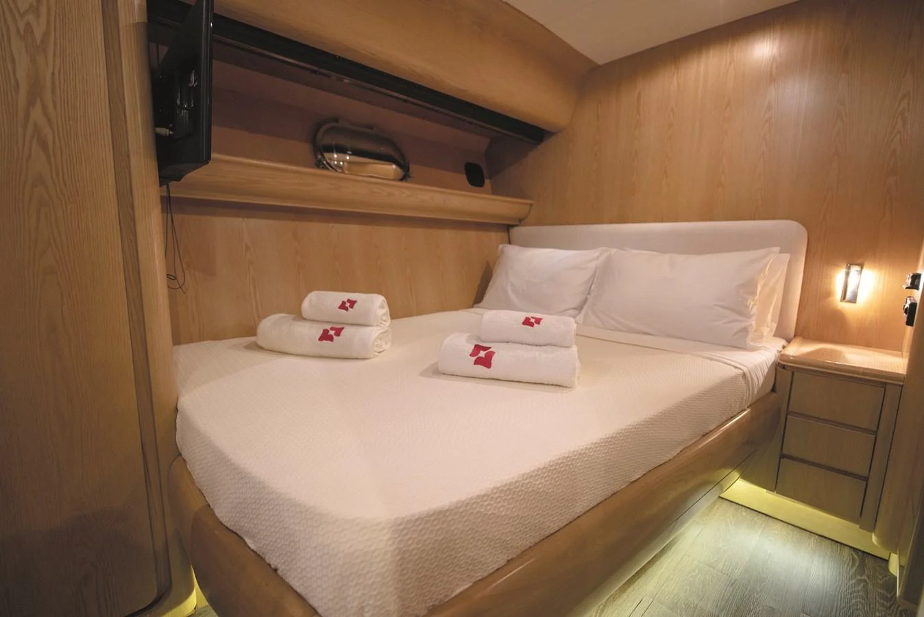 The stateroom features a cozy bed with neatly arranged towels, creating a welcoming and comfortable atmosphere. aboard KISS Yacht for Sale
