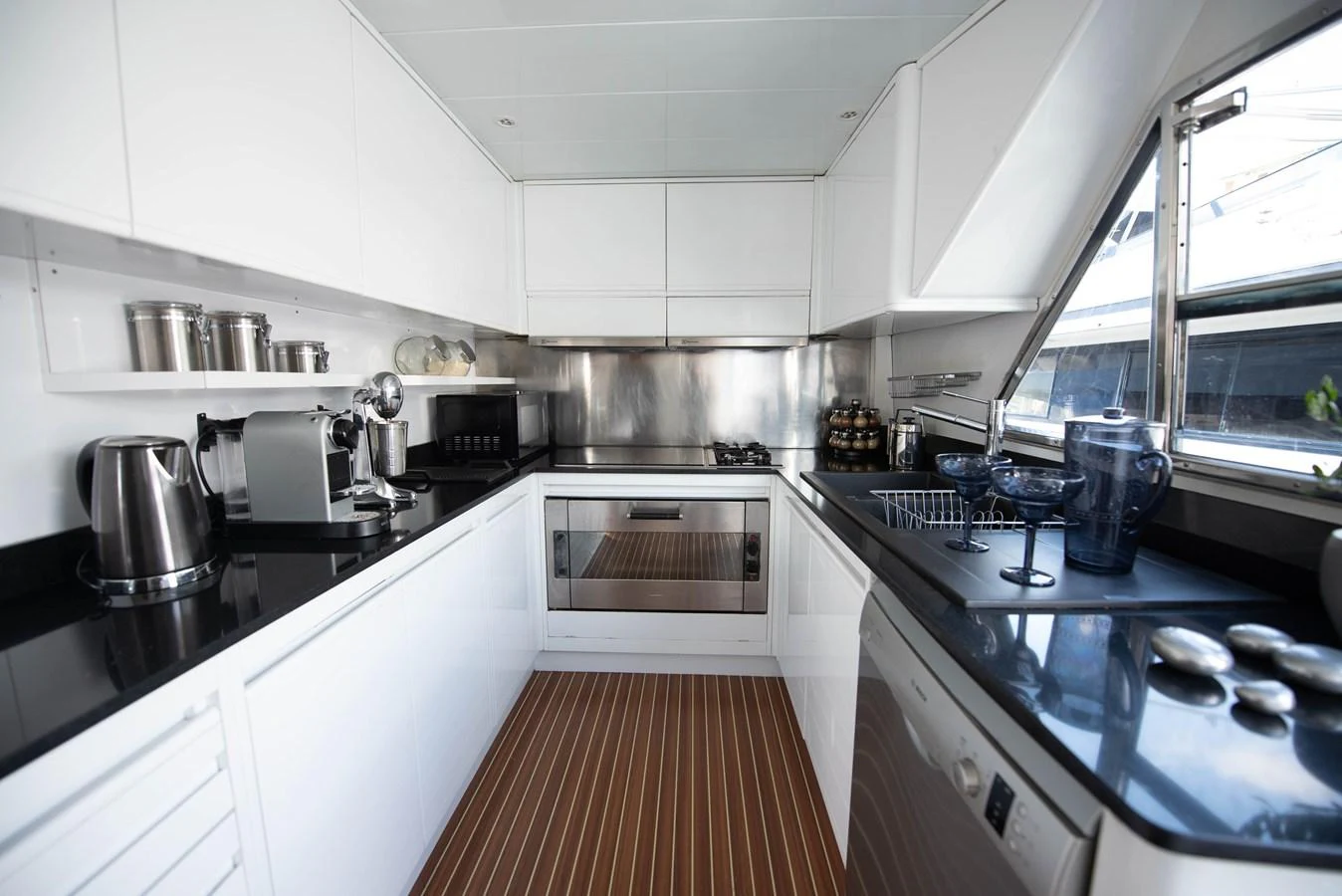 The yacht's galley is equipped with modern appliances and sleek countertops, offering a functional and stylish space for meal preparation. aboard KISS Yacht for Sale